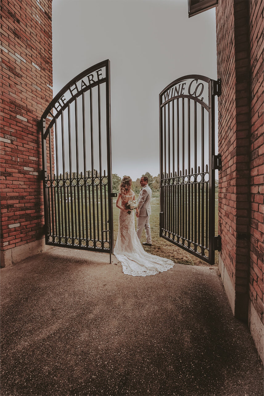 A couple walking through the gates at The Hare Wine Co. in Niagara-on-the-Lake.