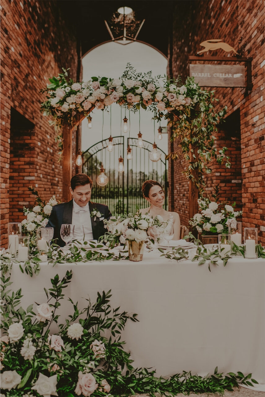 A couple seated at their wedding reception at The Hare Wine Co. in Niagara-on-the-Lake.